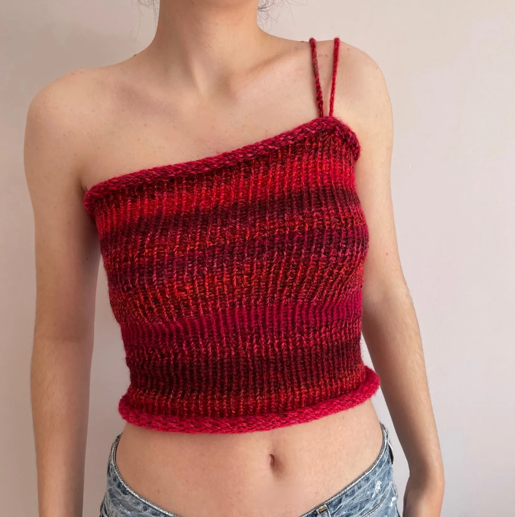 Handmade knitted asymmetrical top in red tones